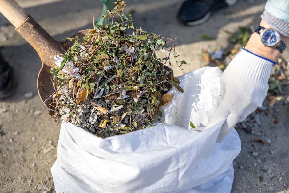An outdoor scene in a commercial or urban area shows multiple overflowing waste collection bins and numerous discarded rubbish bags and boxes spilling onto the paved surface. The central focus is on a